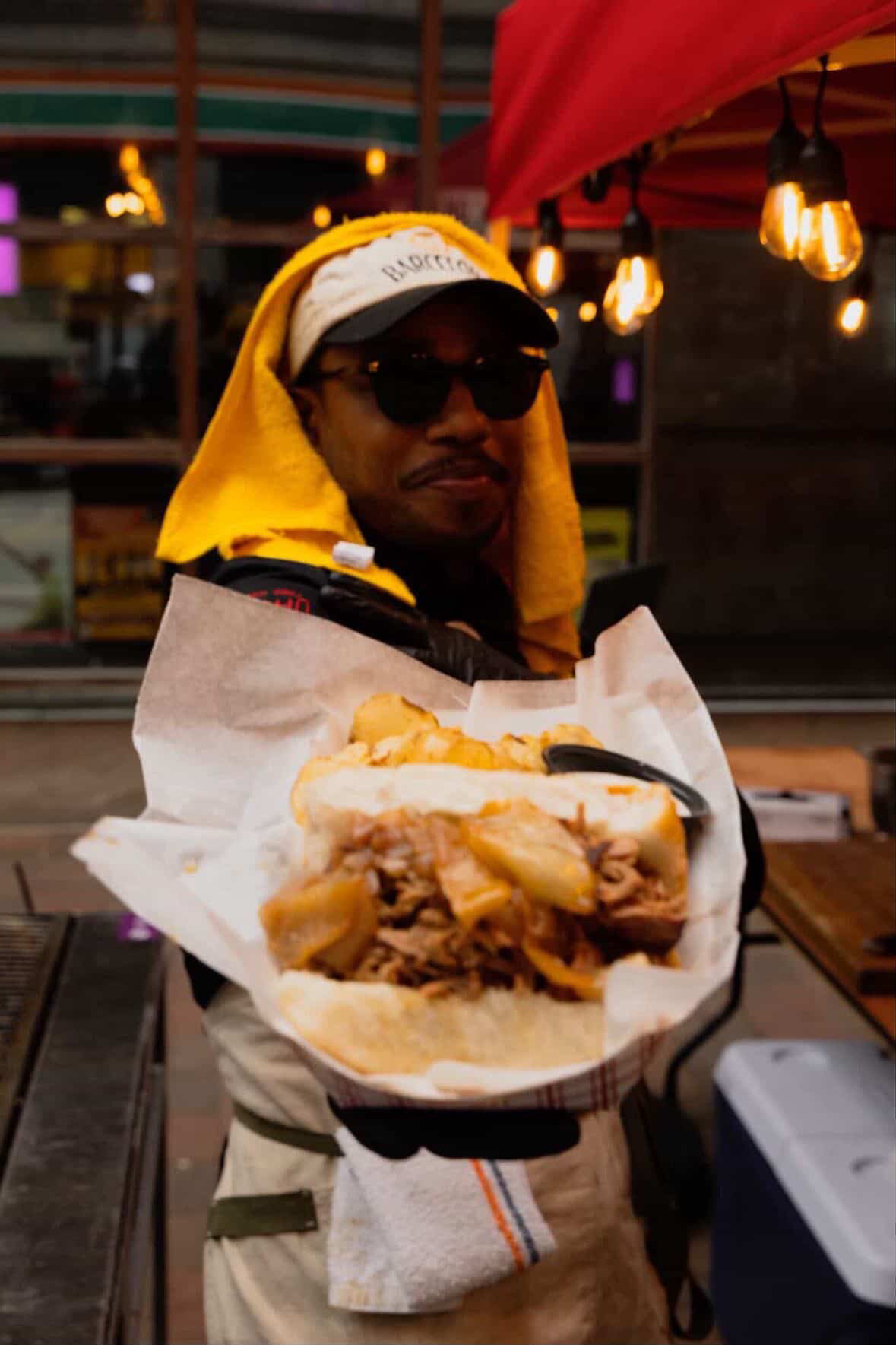 Chef Darrel holding a plated sandwich in service